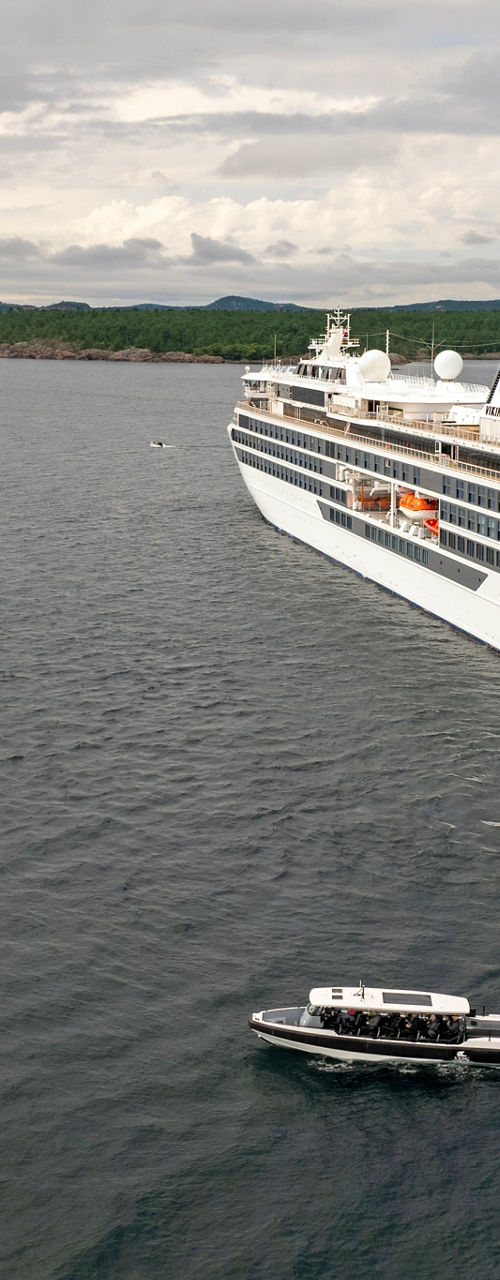 Luxury cruise ship with small boat nearby