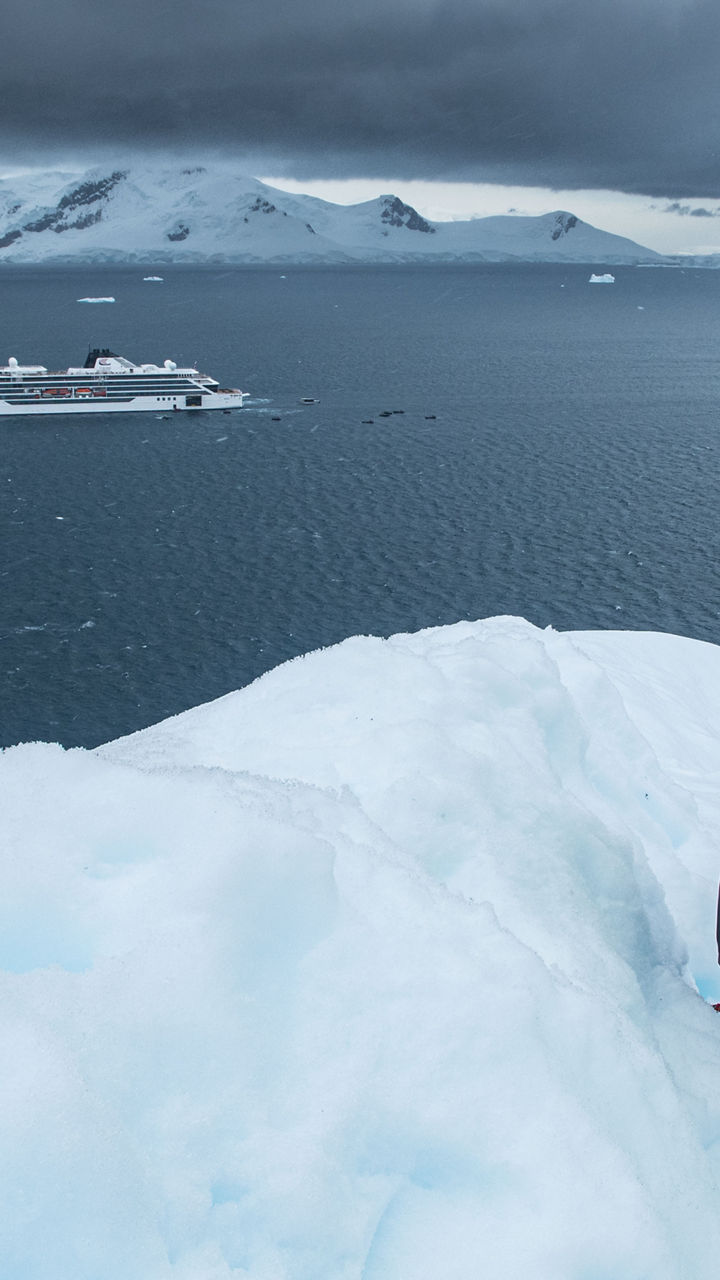 Explorer in bright jacket overlooking icy waters