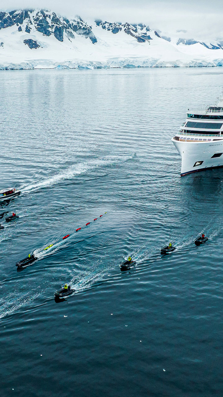Cruise ship with small boats in icy waters
