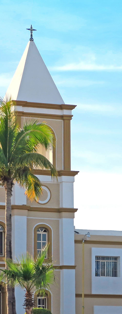Historic church with palm trees under blue sky