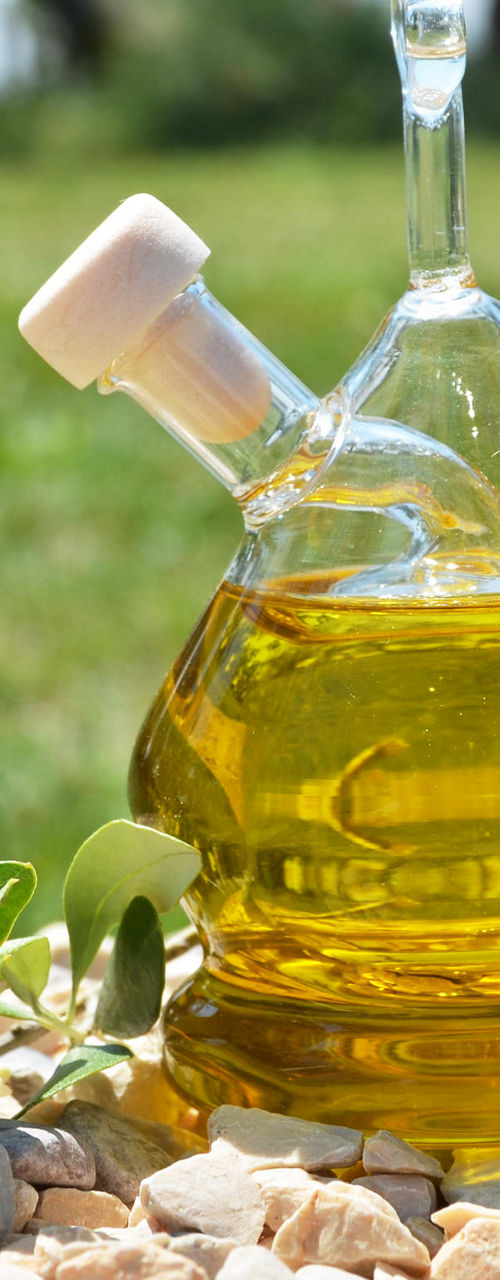 Glass bottle of olive oil outdoors