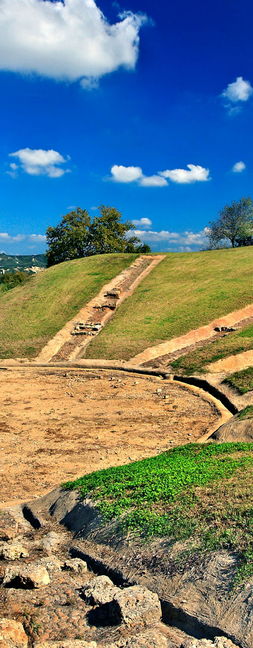 Ancient amphitheater ruins under blue sky