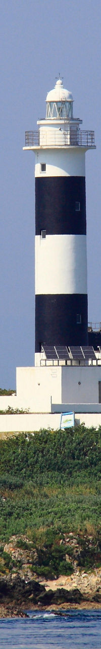 Black and white lighthouse on grassy island