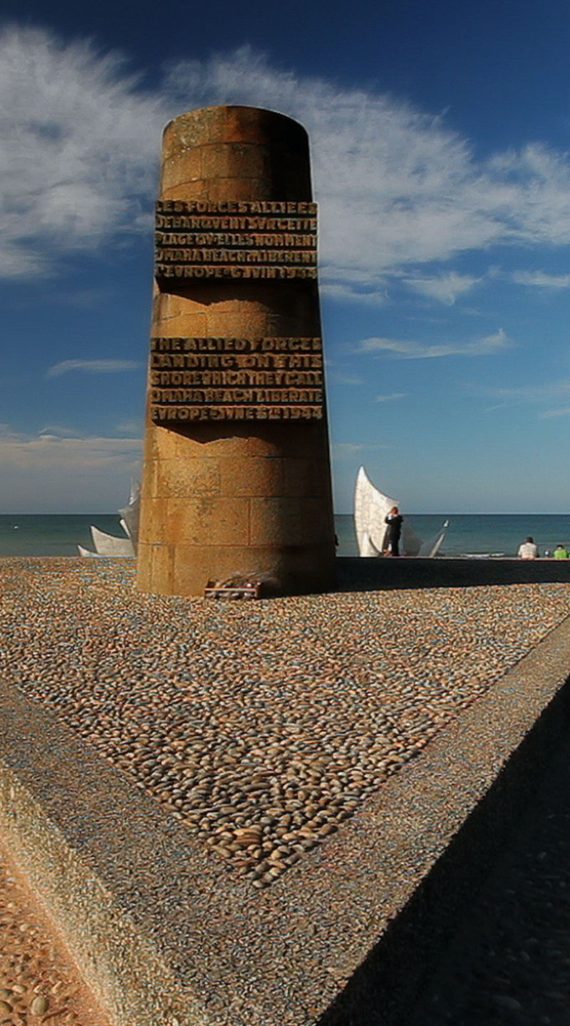 Beach monument with flags under clear sky