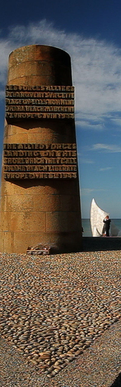Beach monument with flags under clear sky