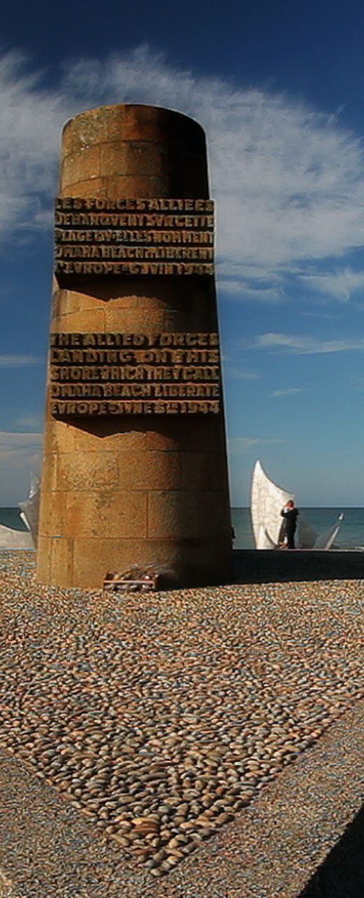 Beach monument with flags under clear sky
