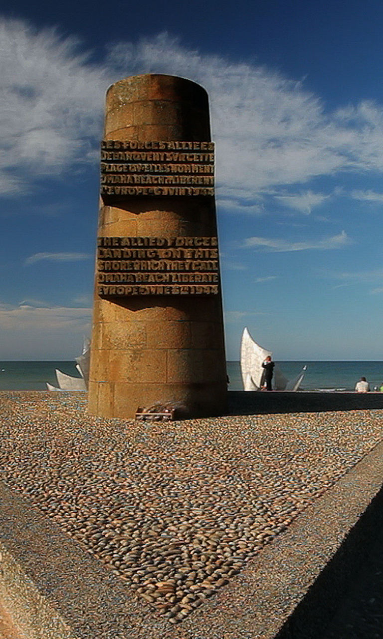 Beach monument with flags under clear sky