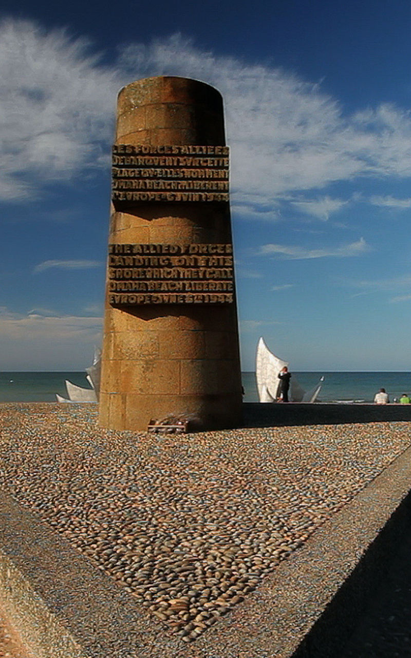 Beach monument with flags under clear sky