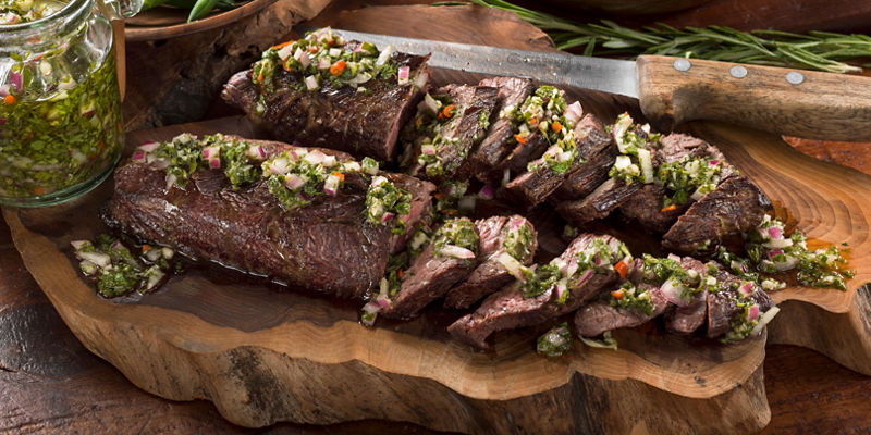 Sliced grilled steak with chimichurri sauce