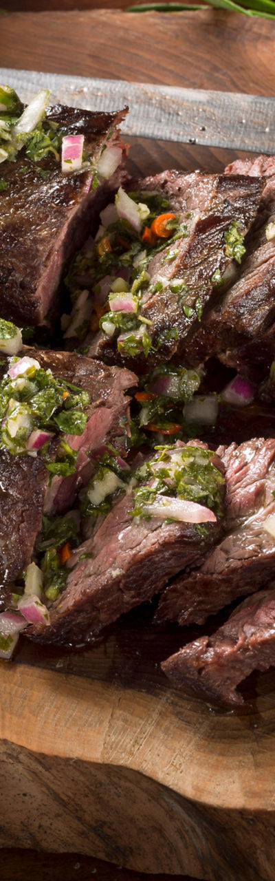 Sliced grilled steak with chimichurri sauce