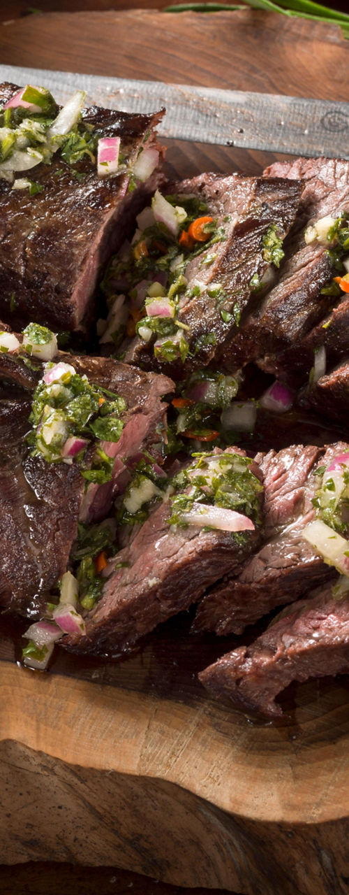 Sliced grilled steak with chimichurri sauce