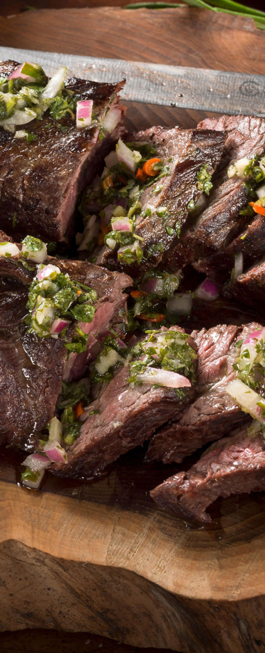 Sliced grilled steak with chimichurri sauce