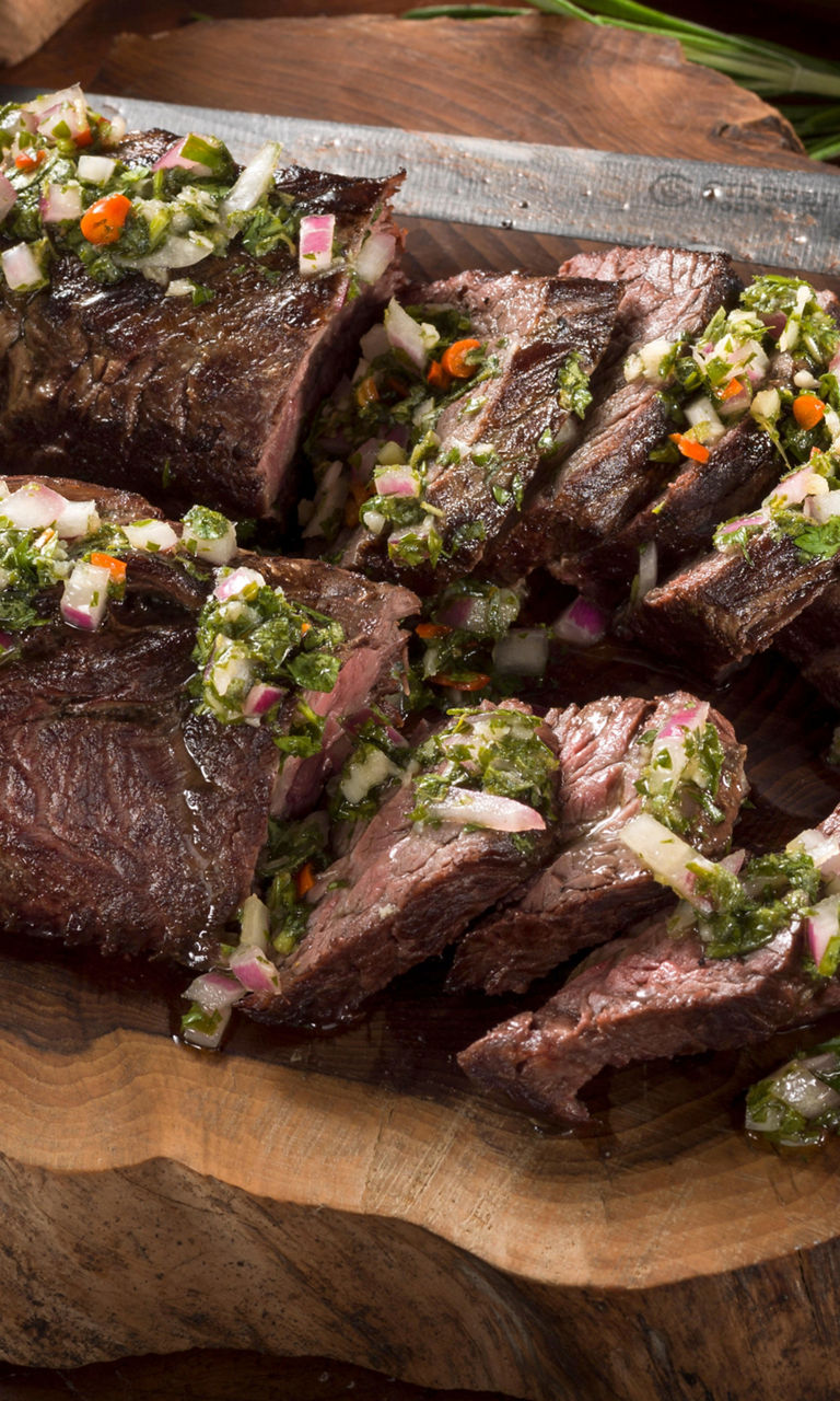 Sliced grilled steak with chimichurri sauce