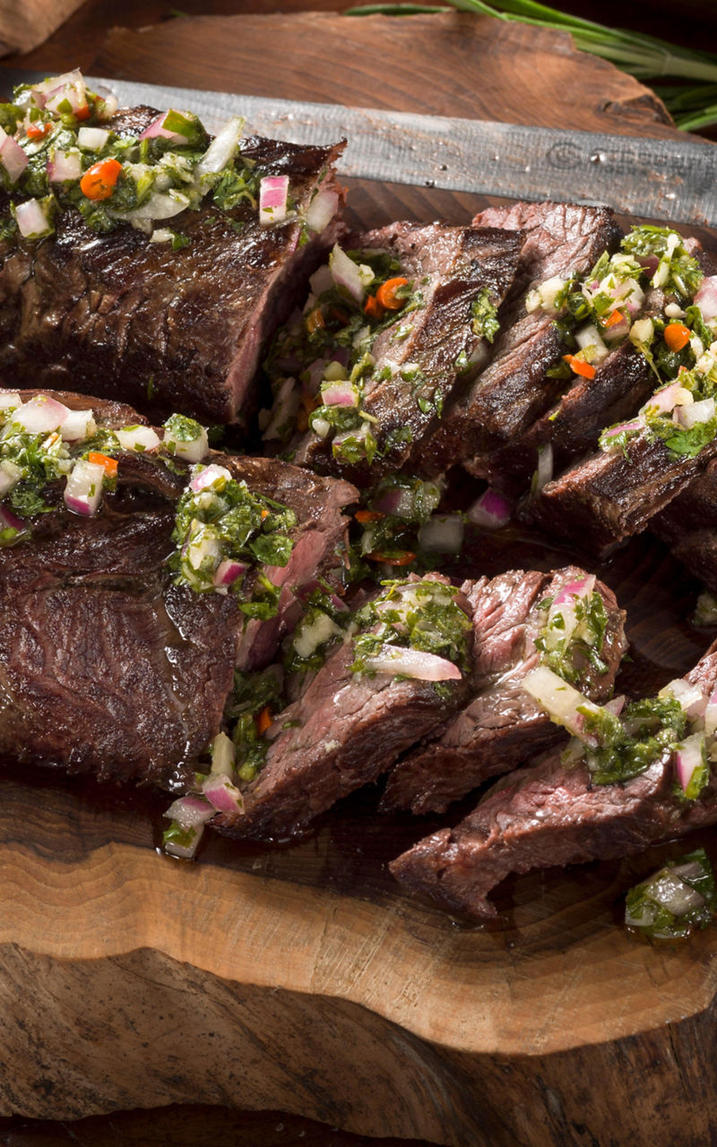 Sliced grilled steak with chimichurri sauce