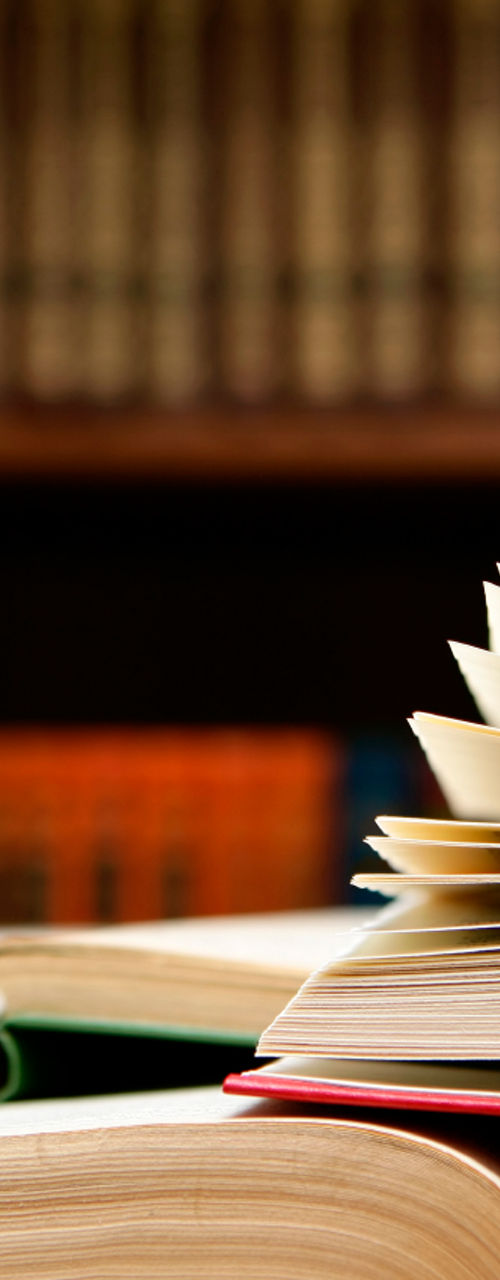 Open book on library table with shelves