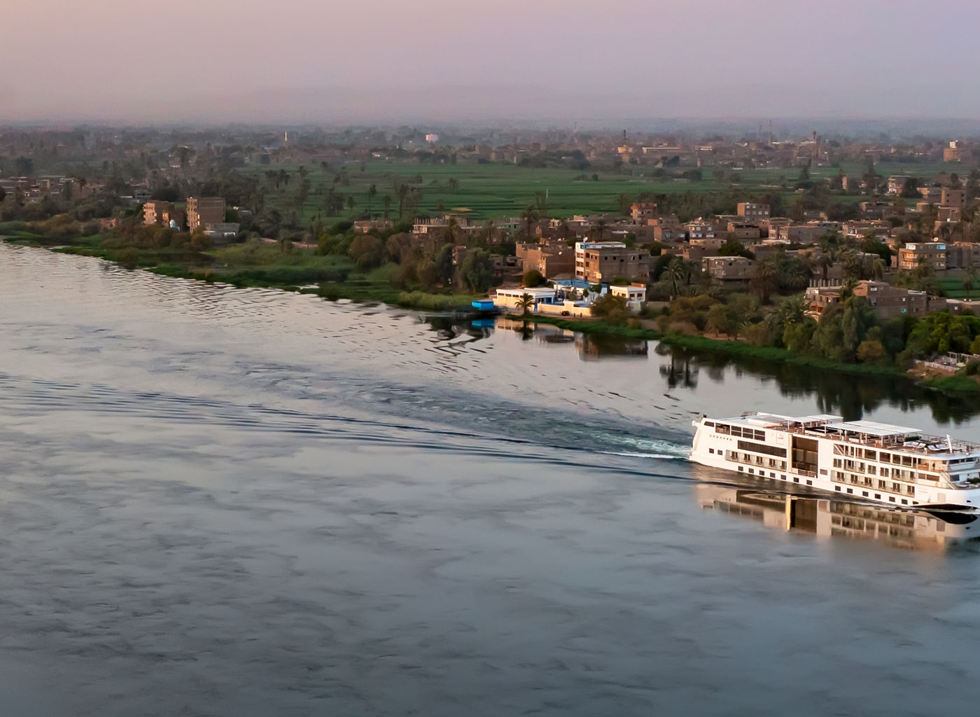 River cruise ship on serene Nile at sunset
