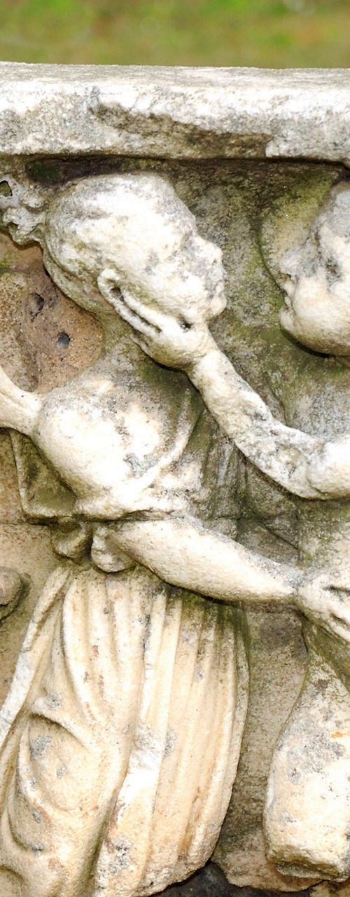 Ancient stone carving with cherubs outdoors