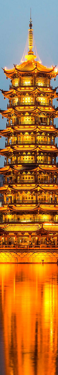 Illuminated twin pagodas by serene lake