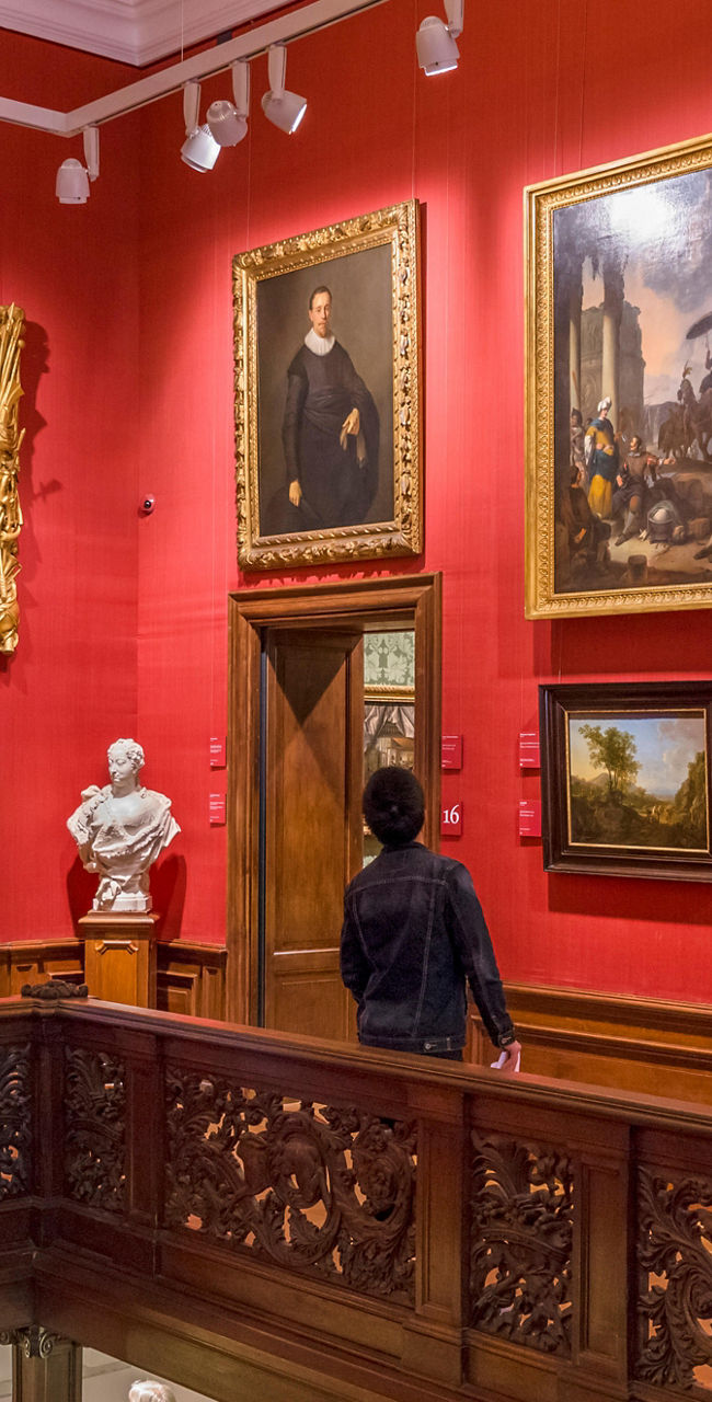 Art gallery with red walls and visitors