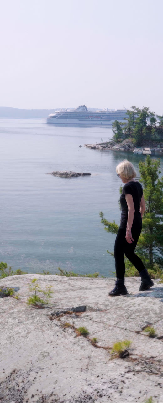 Two hikers explore scenic lakeside cliffs