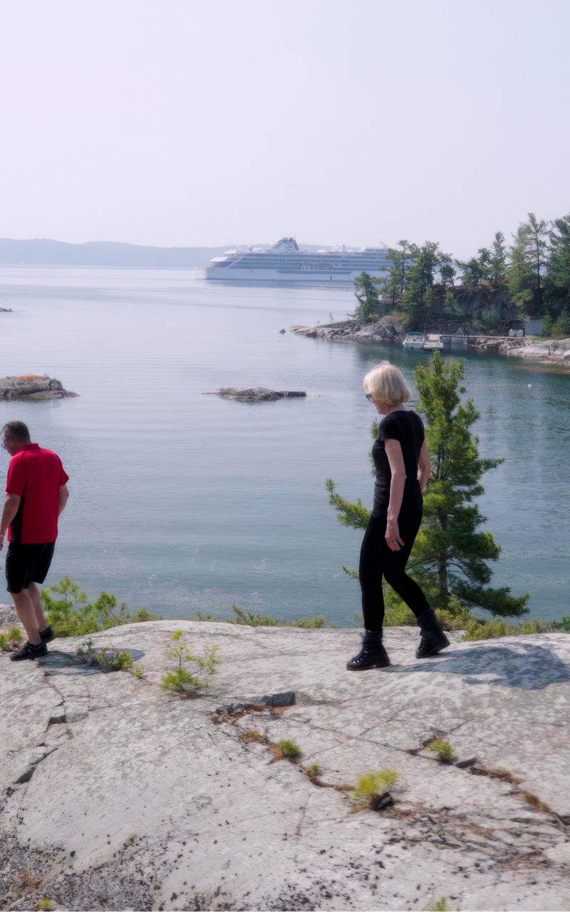 Two hikers explore scenic lakeside cliffs