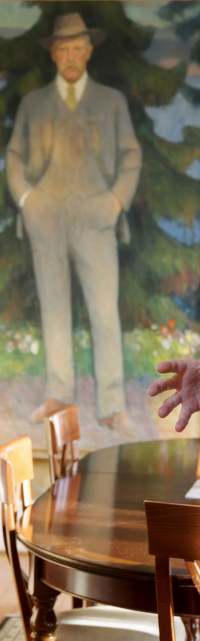 Two men discussing in art-filled room