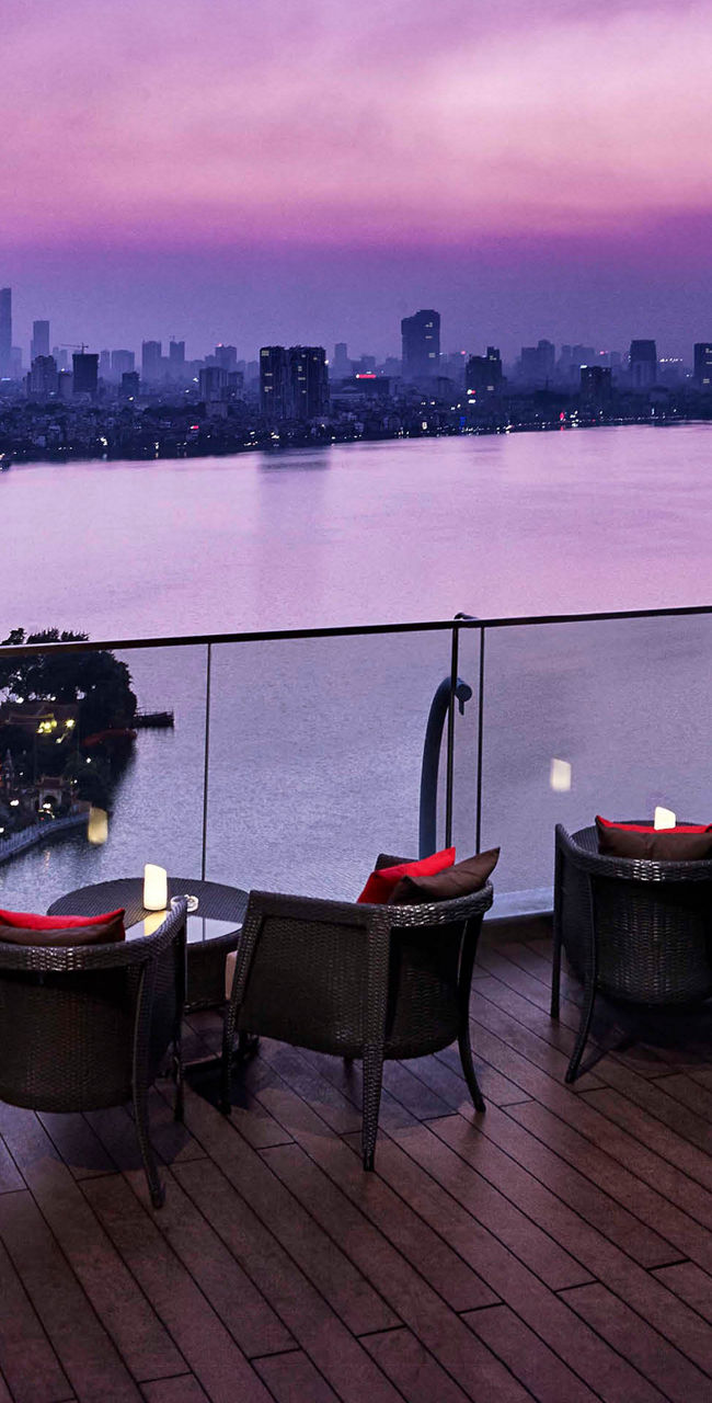 Rooftop lounge overlooking city skyline at dusk