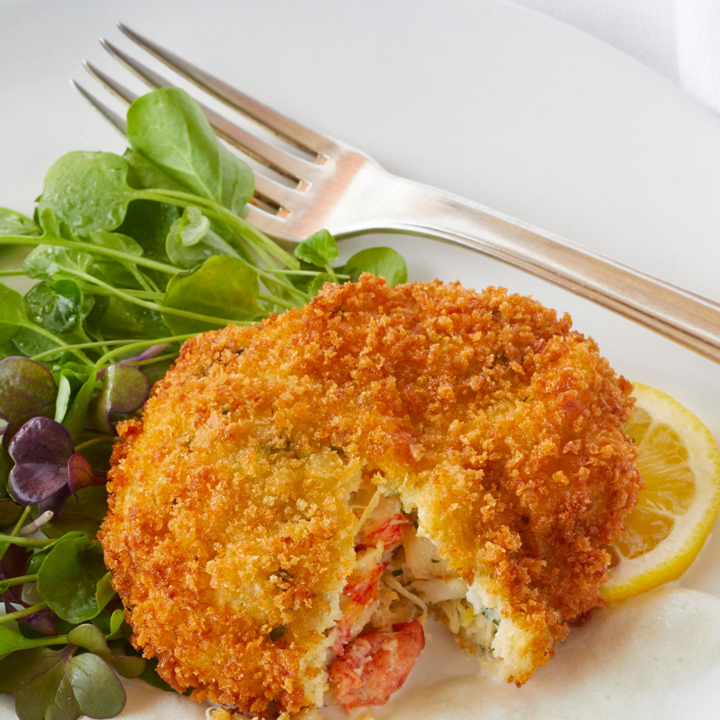 Crispy seafood cake with fresh greens