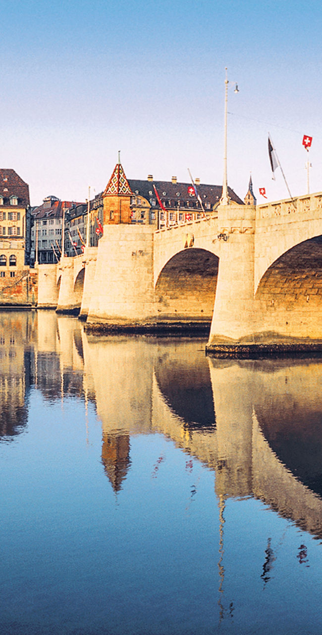 Historic bridge over calm river in Basel