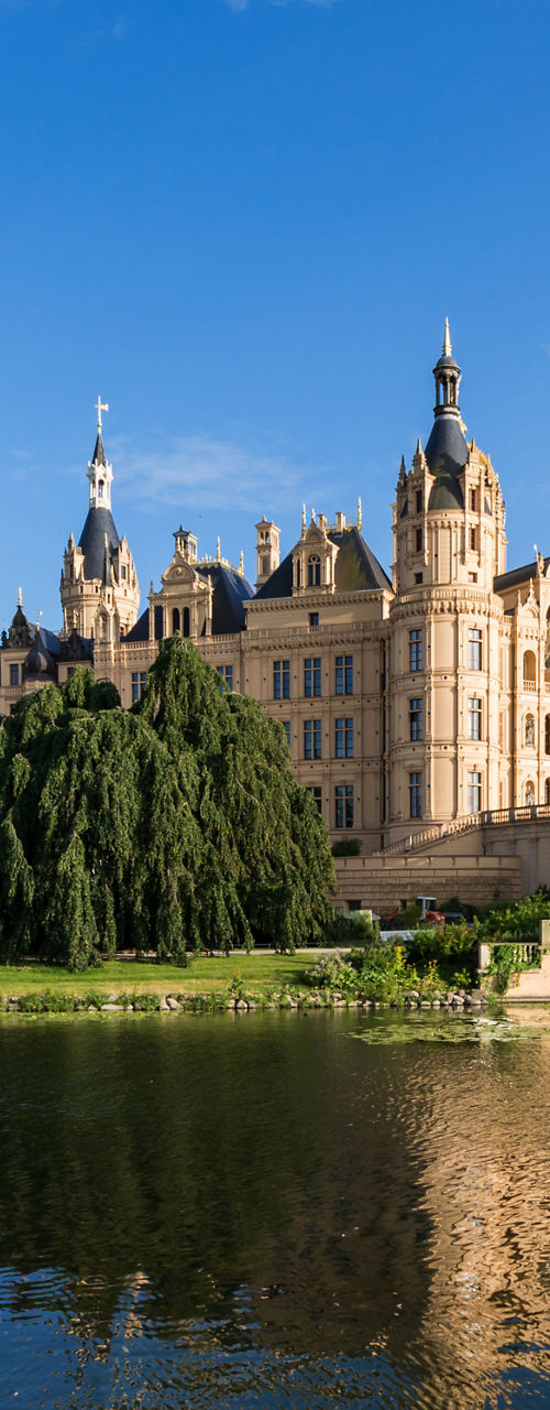 Historic lakeside castle under clear blue sky