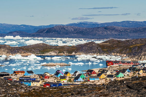 Colorful Arctic village with icebergs in view