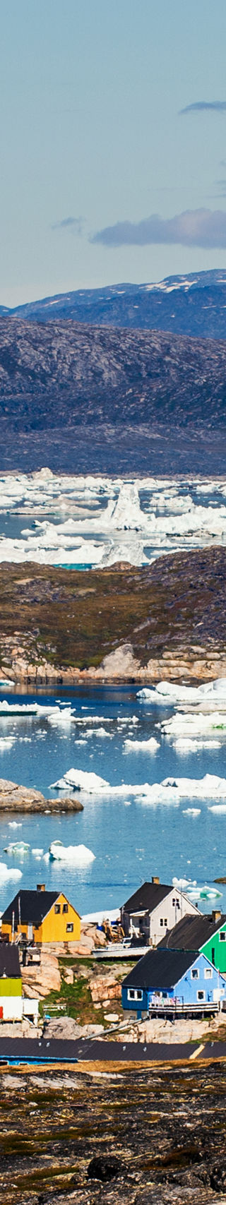 Colorful Arctic village with icebergs in view
