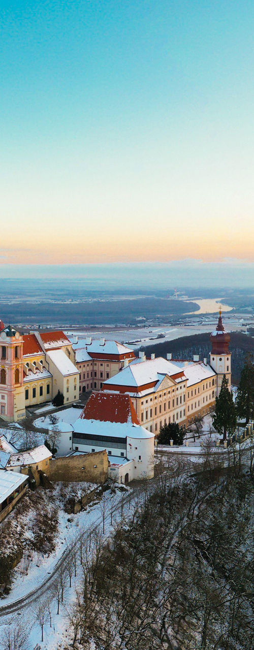 Snow-covered castle on a hill at sunset