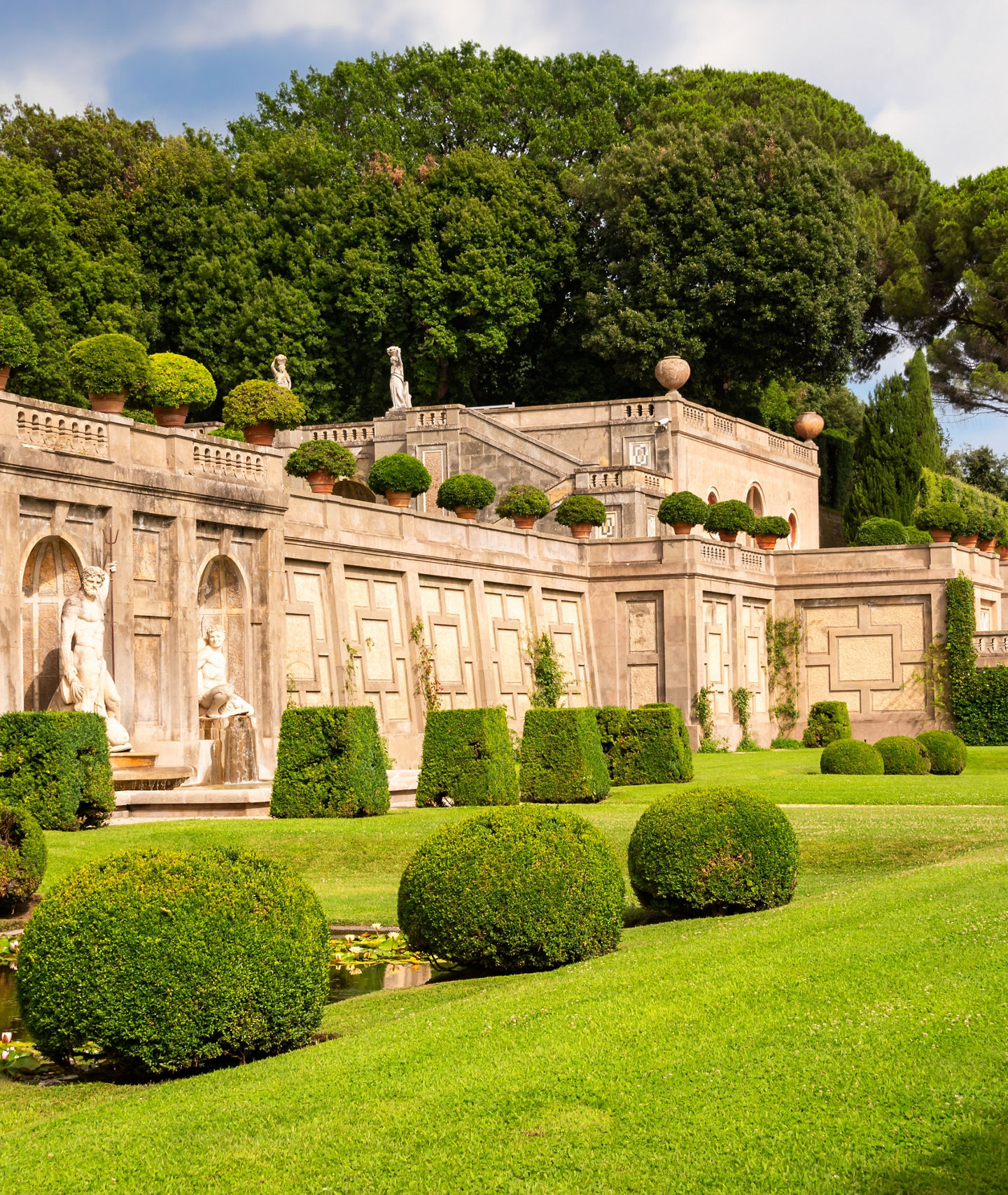 Elegant garden with statues and hedges