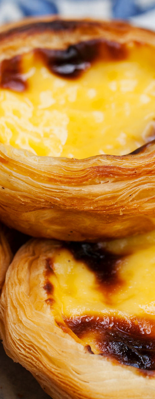 Golden Portuguese custard tarts on paper