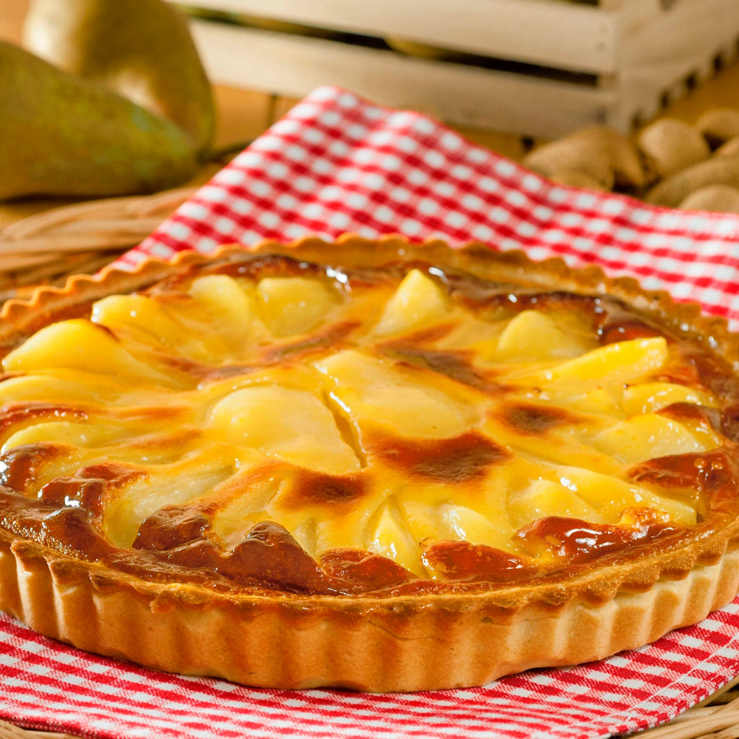 Golden pear tart on red checkered cloth