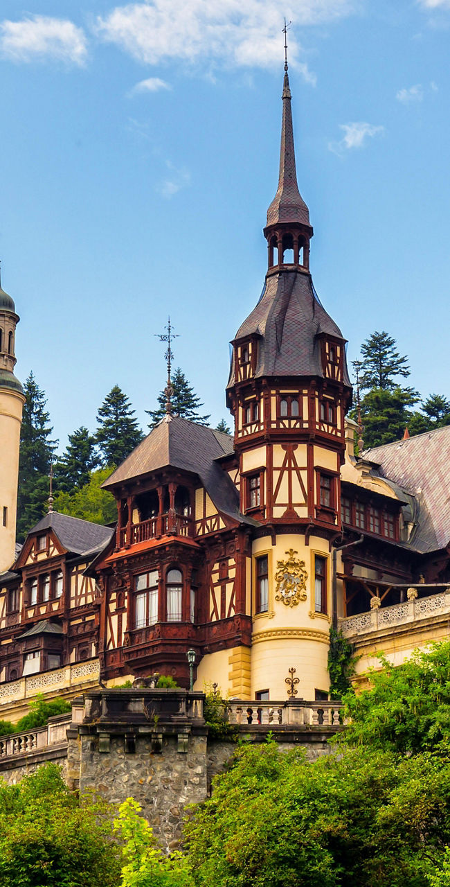 Peles Castle in scenic mountain landscape