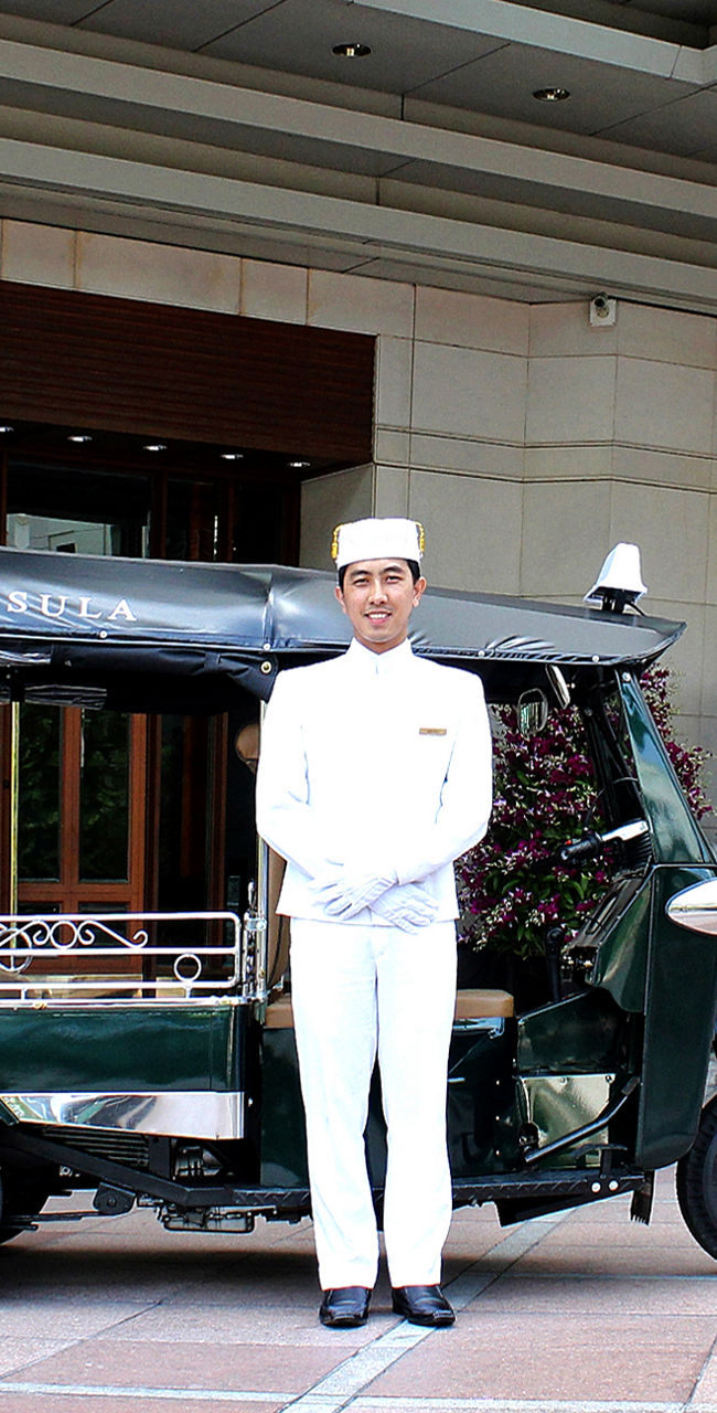 Hotel entrance with tuk-tuk and uniformed staff