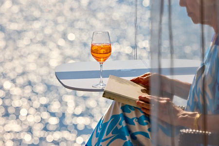 Woman reading by the sparkling sea