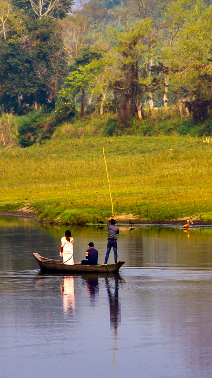 Three people fishing on calm river
