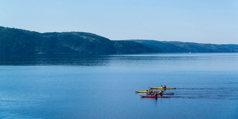 Kayakers on serene lake with distant hills