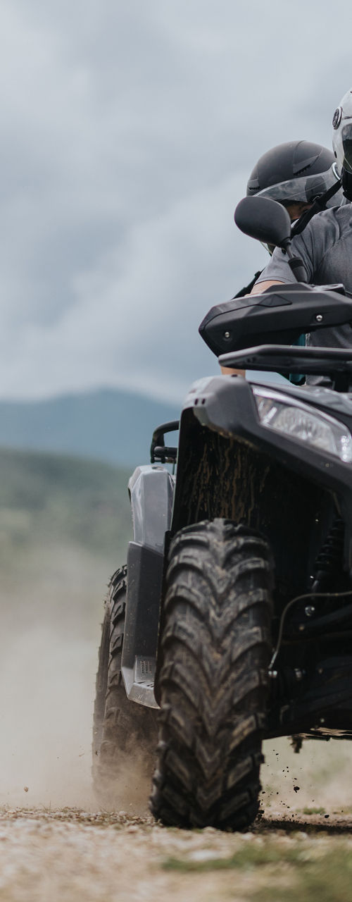 Man riding ATV on dirt trail outdoors