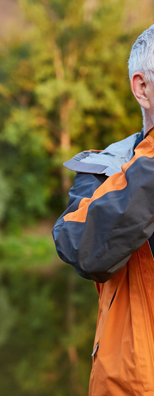 Photographer in orange jacket by nature