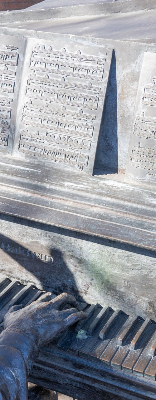 Bronze statue of pianist outdoors