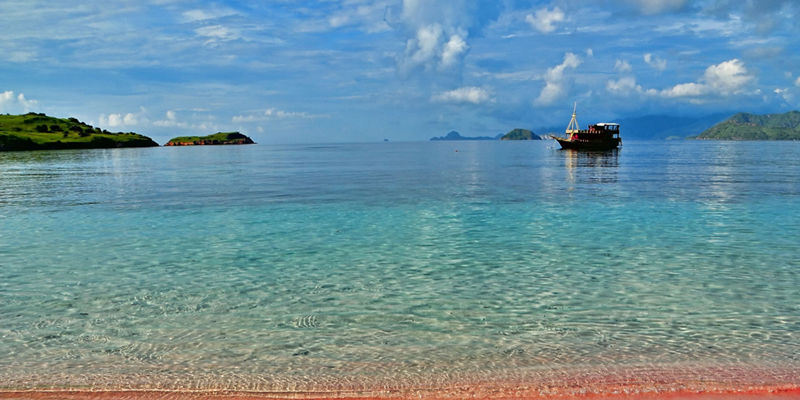 Scenic beach with pink sand and boat