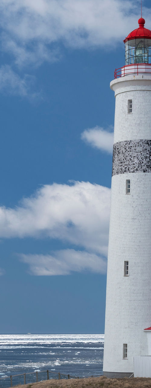 Coastal lighthouse with red roof and ocean view