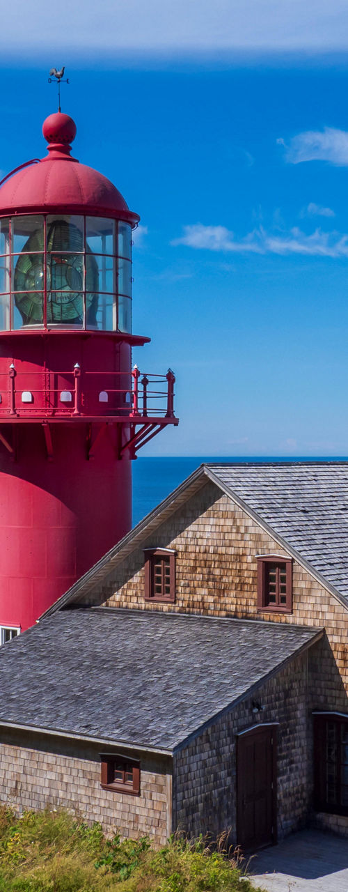 Red lighthouse overlooking ocean and coastline