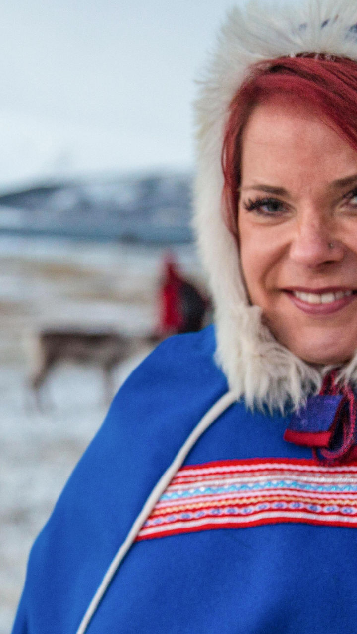 Person in traditional attire with reindeer