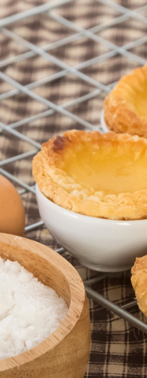 Egg tarts with baking ingredients on table