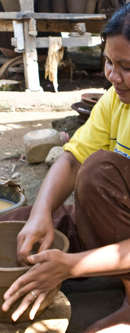 Woman crafting pottery in rural setting